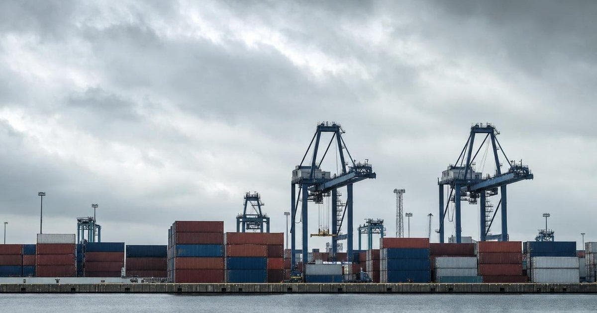 Container stacks at a cargo port reflecting sanctions case settlement and ongoing regulatory scrutiny