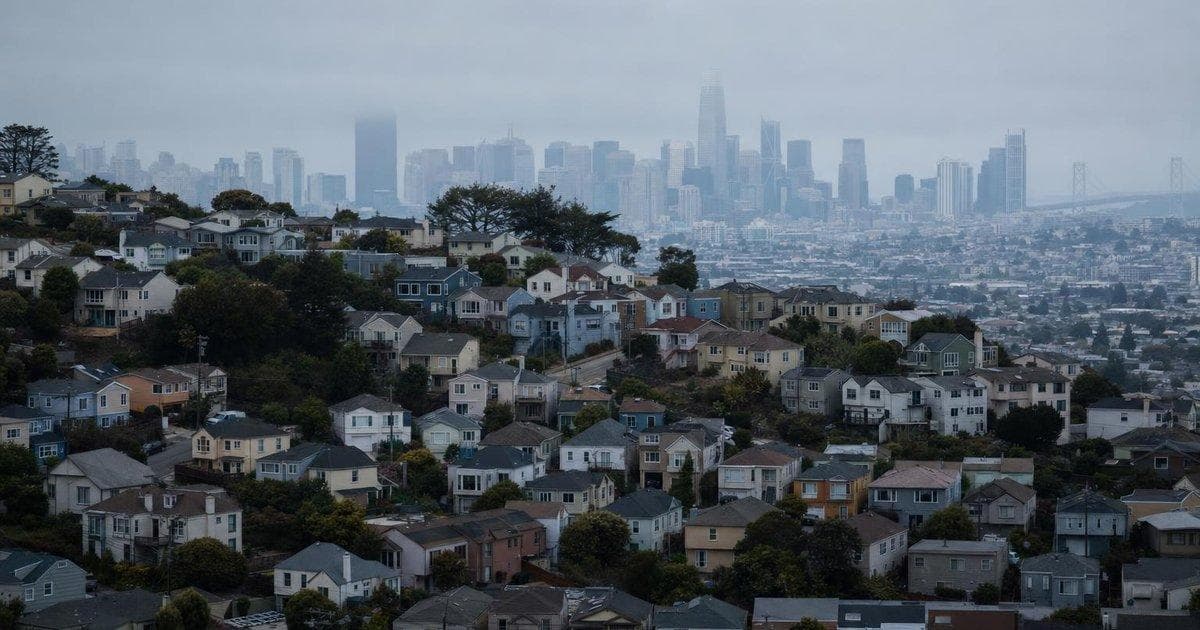 Dense suburban housing under hazy skies illustrating Australia housing strain and affordability pressures