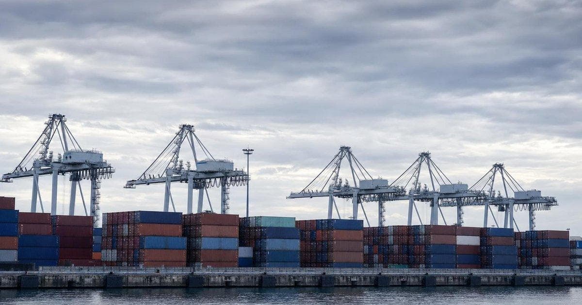 Stacked cargo containers at a North American port illustrating long-term USMCA trade talks
