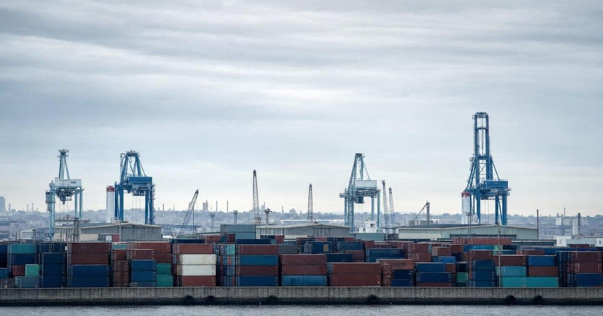 Shipping containers at a cargo port illustrating tariff tensions and trade dispute ahead of election