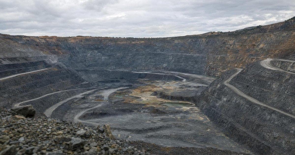 Large open-pit gold mine symbolizing creation of new $18.5B gold major in mining sector
