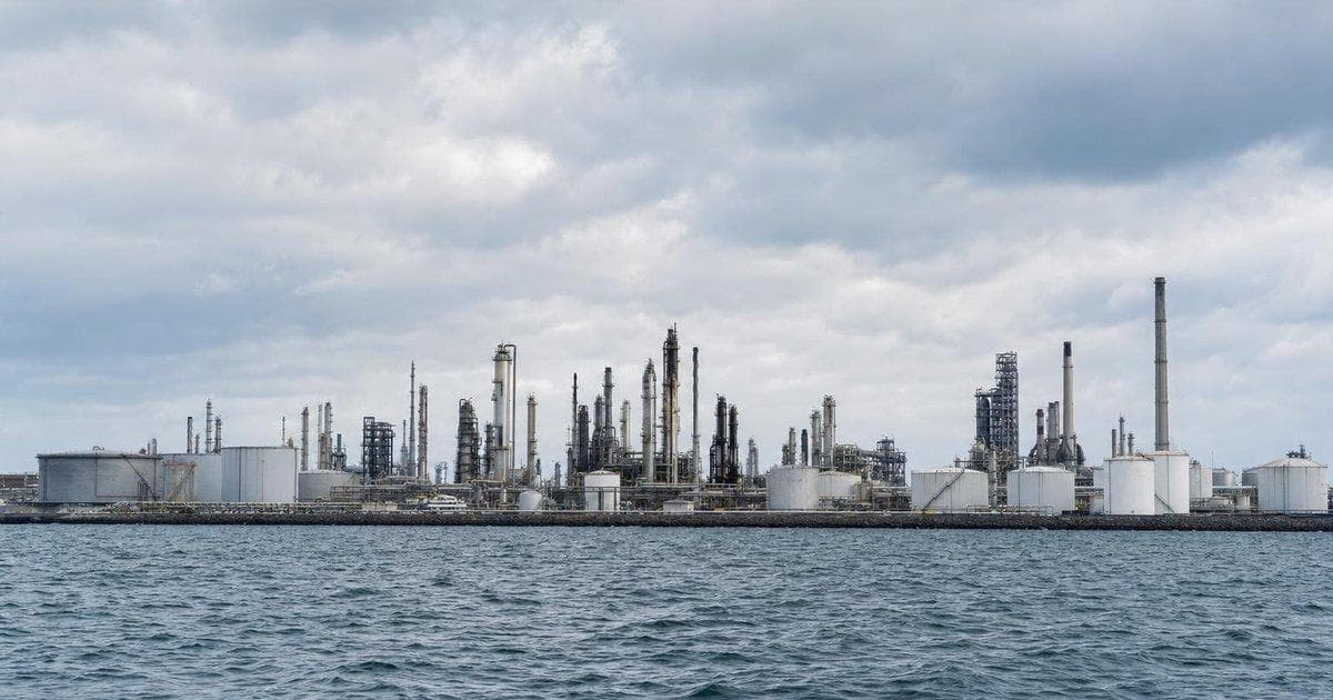 Mediterranean oil refinery complex by the sea illustrating refinery stake acquisition and energy security focus