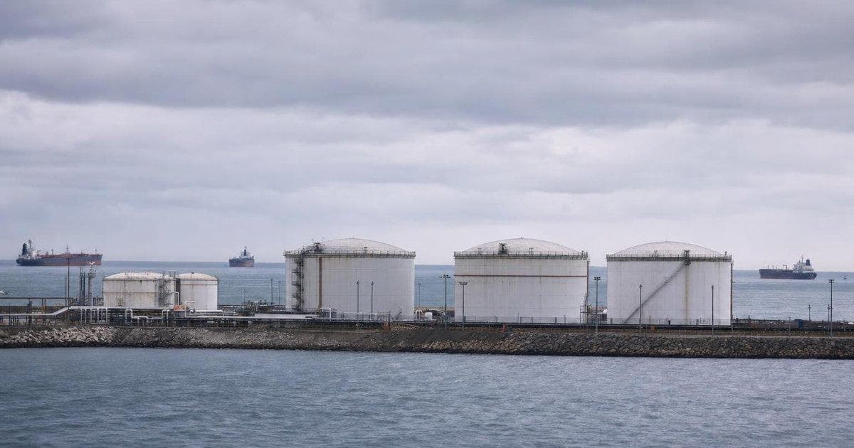 Crude oil storage tanks at a coastal terminal as supply strains tighten the global oil market