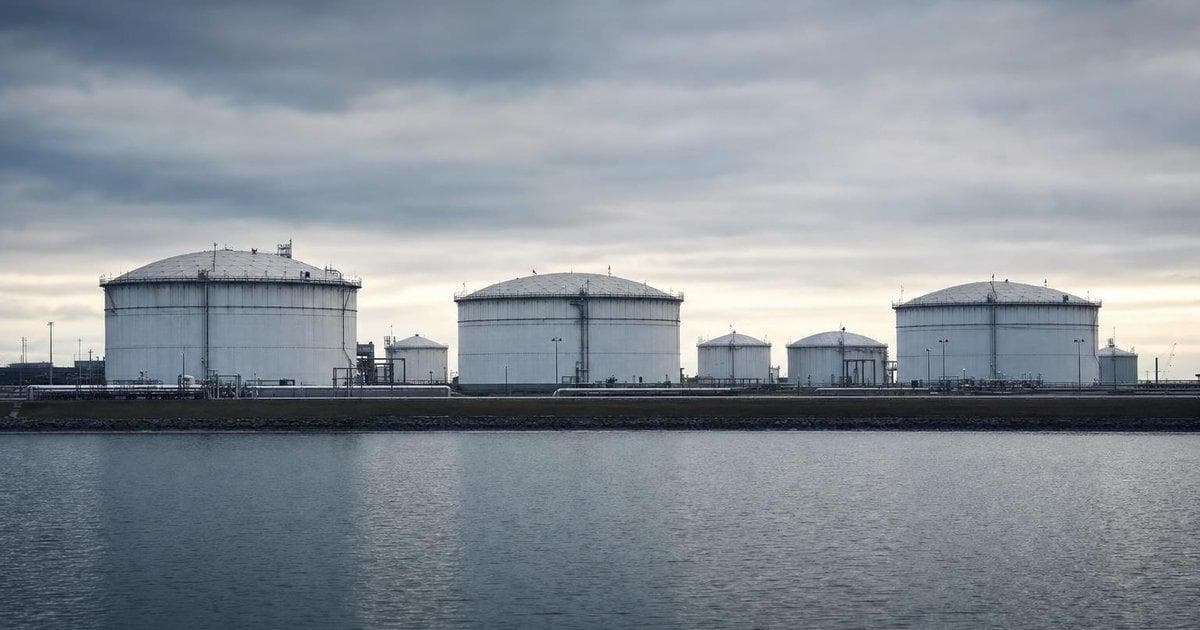 Crude oil storage tanks at an industrial terminal as easing tensions pressure oil prices lower