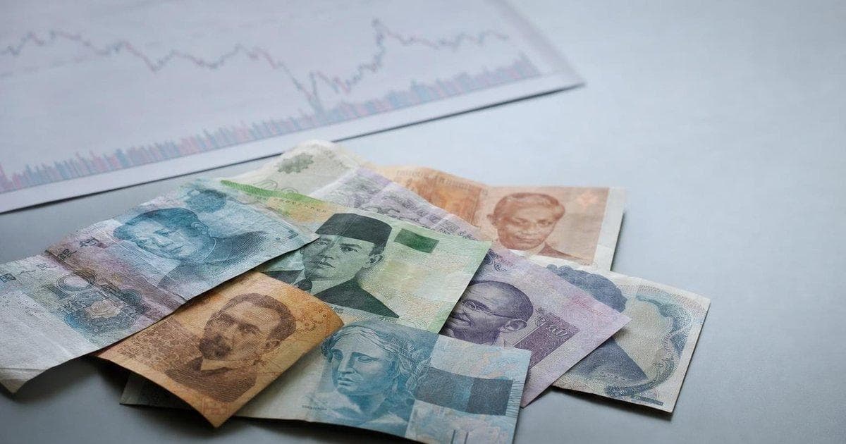 Emerging market banknotes on a trading desk illustrating EM FX carry trade rebound in currencies
