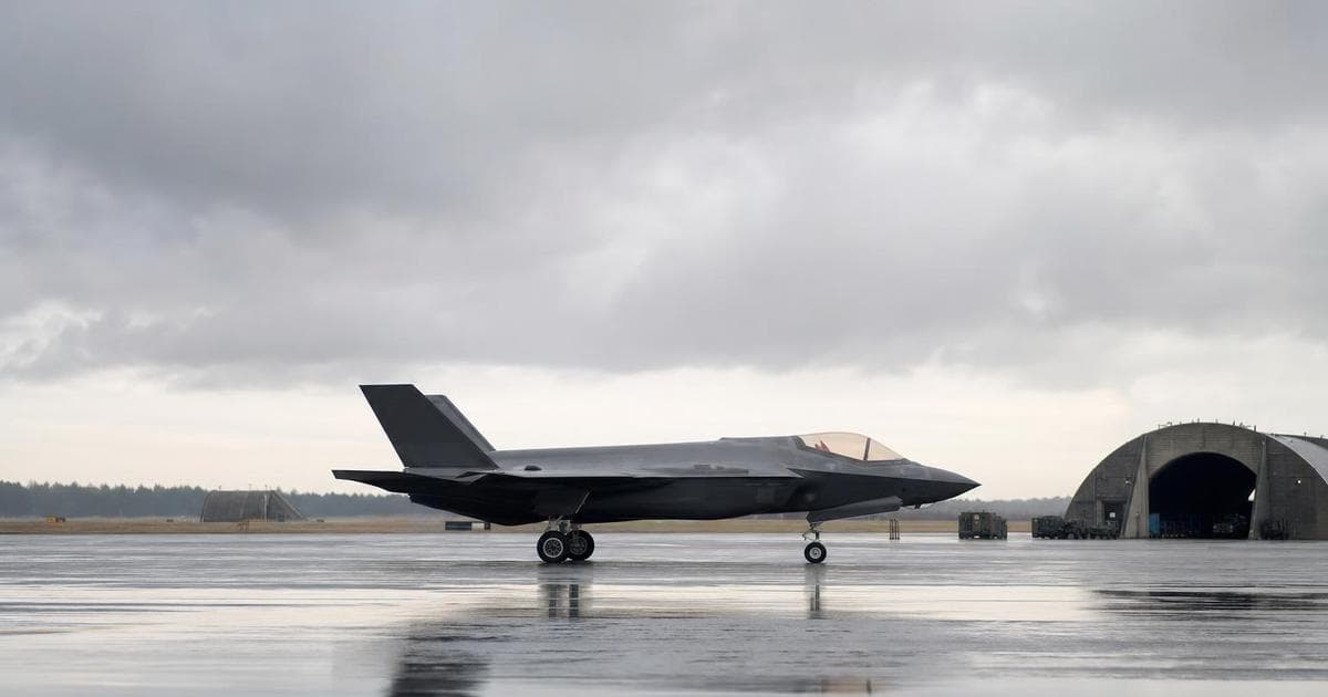 Defense stock comparison LMT vs GD illustrated by a modern fighter jet on a military runway in Q2 2026