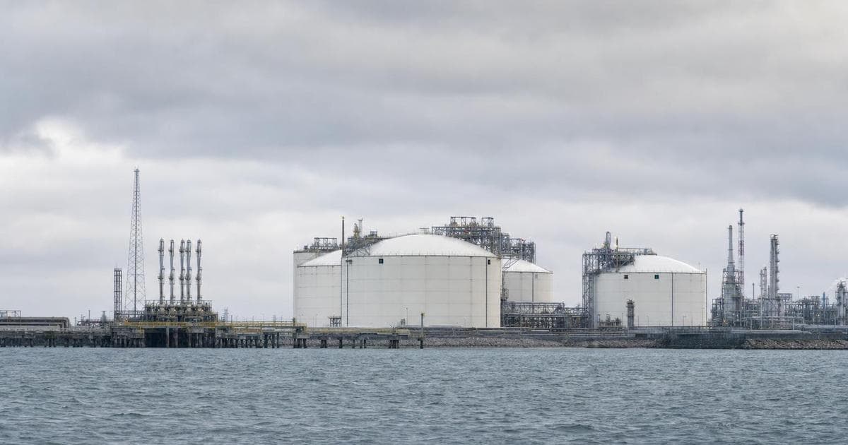 LNG export terminal with large storage tanks and pipelines illustrating top natural gas stocks for 2026 like LNG, EQT, ET