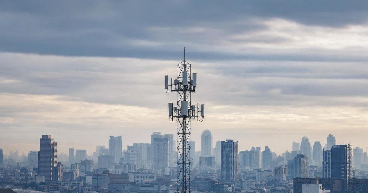 Telecom cell tower over city skyline amid regulatory probe and failed takeover impacting buyer shares